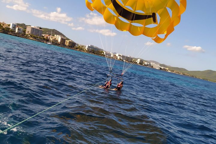a person flying a kite in a large body of water