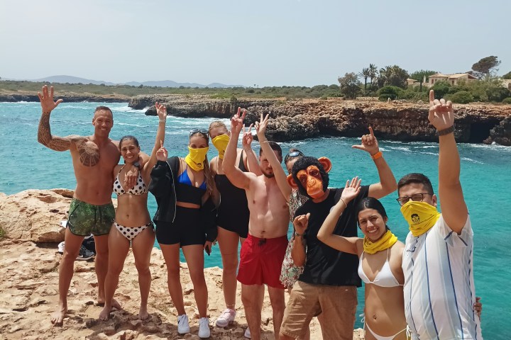a group of people standing on top of a sandy beach