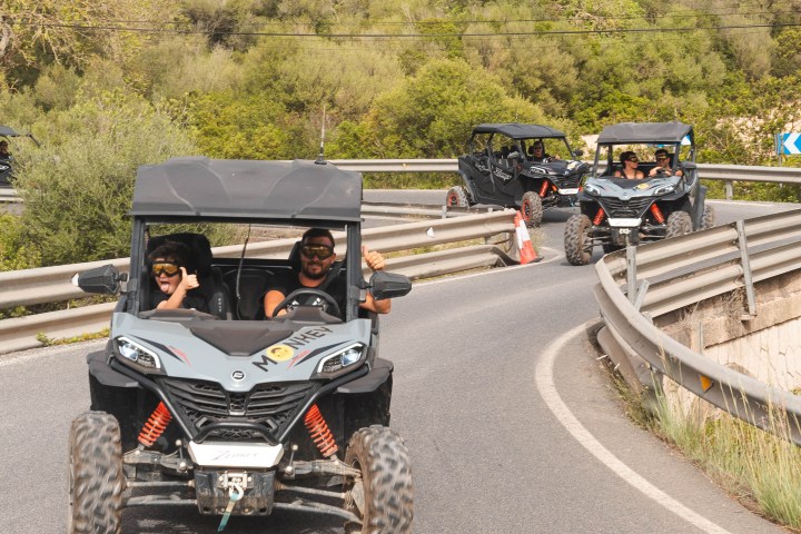 a group of men riding on the back of a truck